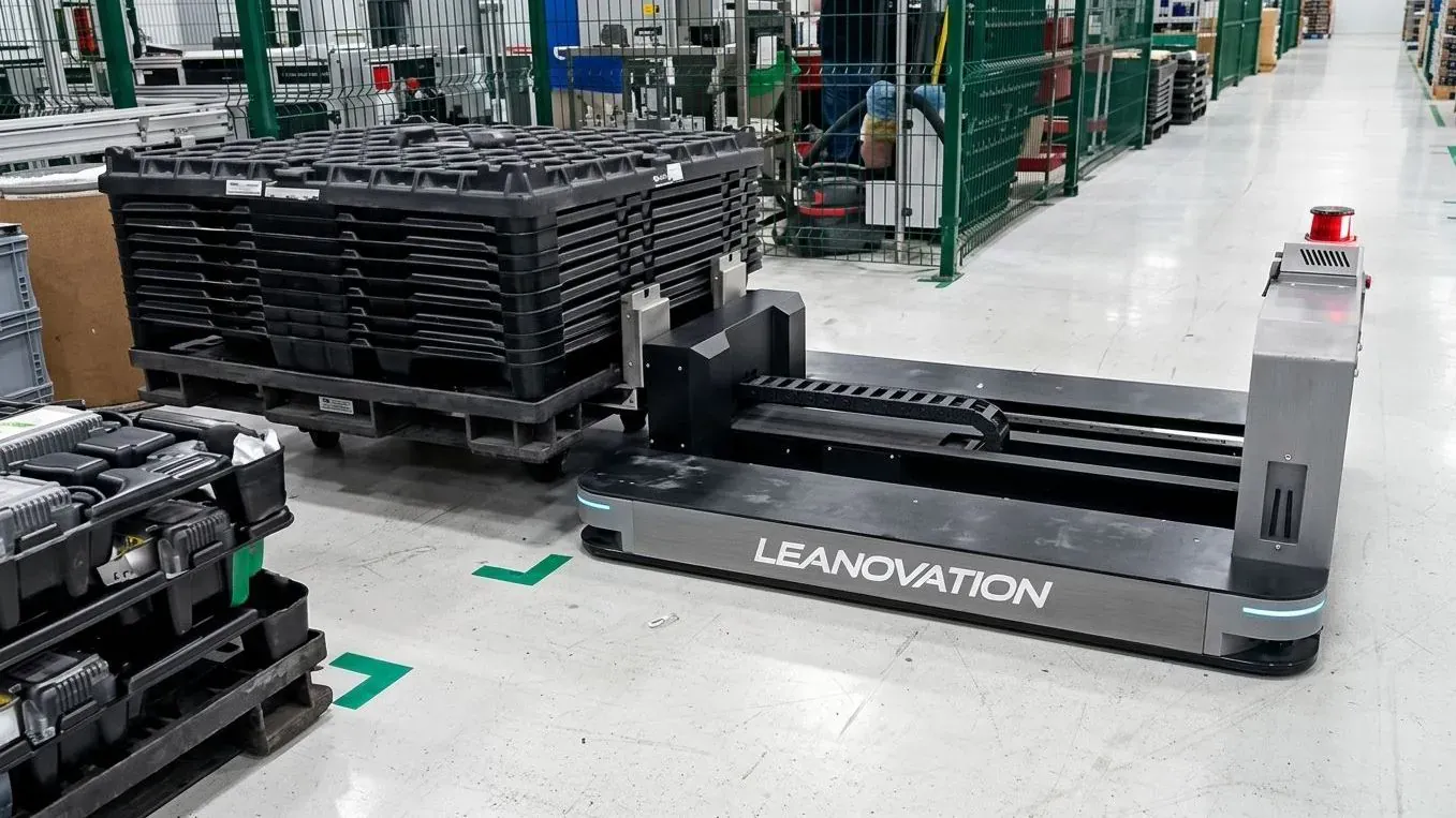 Robot móvil SEER transportando un rack sobre tarima en una nave de almacén.
